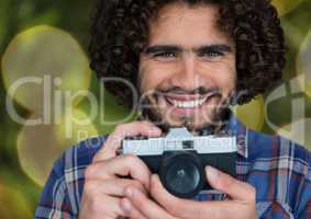 happy photographer with vintage camera. Green and yellow blurred lights background