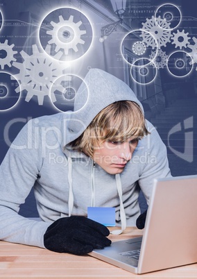 3D Hacker holding a credit card while using a laptop on wood table