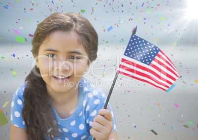 Girl with american flag against blurry beach with flare and confetti