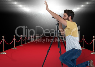 photographer taking a photo in the red carpet with stadium lights on back