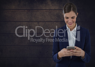 Smiling woman texting against wooden background