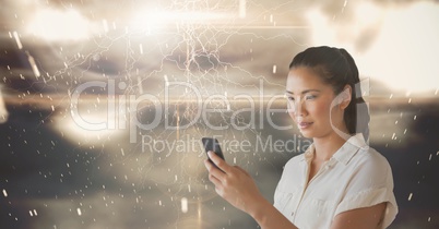 Smiling woman texting against lights