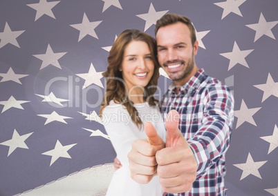 couple thumbs up against fluttering american flag