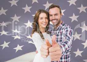 couple thumbs up against fluttering american flag