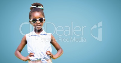 Girl in sunglasses hands on hips against blue background