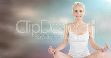 Woman meditating against blurry blue brown background and flare