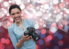 happy young photographer with camera on hands. Pink, blue and white bokeh background