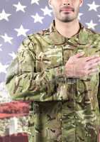 Smiling soldier putting his hand on his heart against american flag background