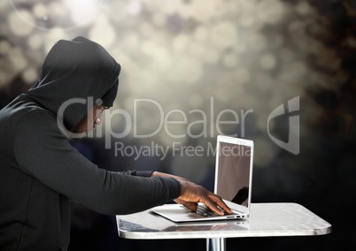 Side view of hacker using a laptop in front of black background