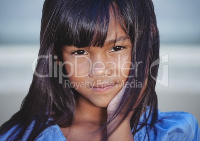 Close up of girl against blurry beach with flare