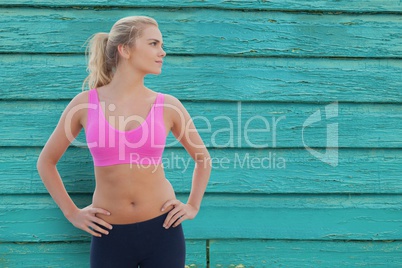 Sporty woman standing on an emerald wooden background