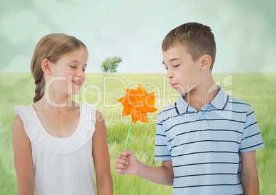 3d Boy and girl with toy windmill against meadow