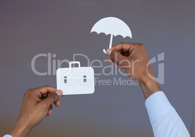 Hands holding umbrella and suitcase in paper