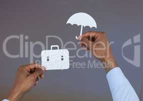 Hands holding umbrella and suitcase in paper