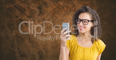 Smiling woman texting against wooden background