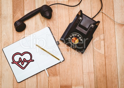 Heart doodle on notepad next to black vintage phone