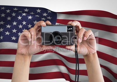 Hands of a photographer taking picture against american flag