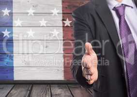 business man shaking his hand against american flag