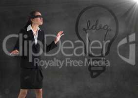 Blindfolded business woman against grey wall with 3d lightbulb graphic and flare