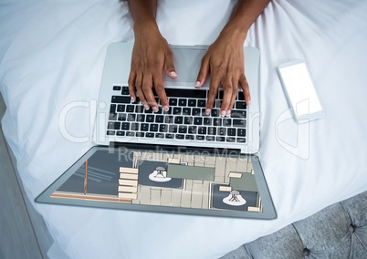 computer with hands on bed. On the screen the design for the wall.