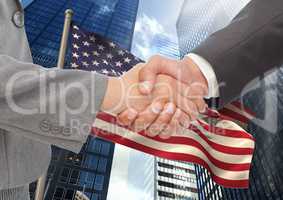 Business people shaking their hands against american flag and skyscraper