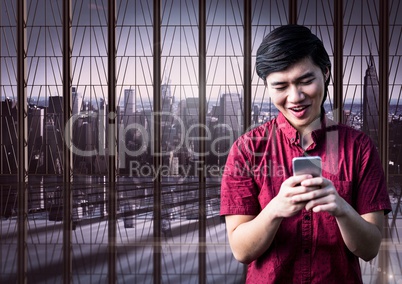 Smiling man texting with city in the background