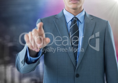 Business man mid section pointing against blurry wall and city doodle
