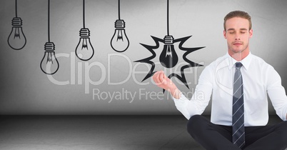 Business man meditating in grey room with 3D lightbulb graphics