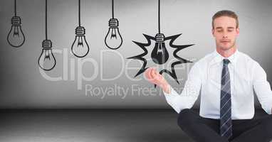 Business man meditating in grey room with 3D lightbulb graphics