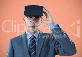 Man in virtual reality headset against orange background