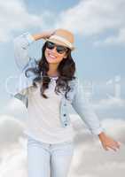 Woman with hand on summer hat against sunny sky