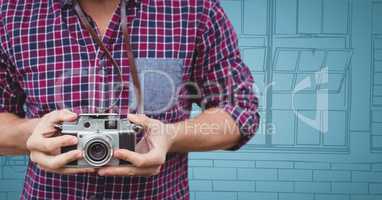 Millennial man mid section with camera against blue hand drawn windows