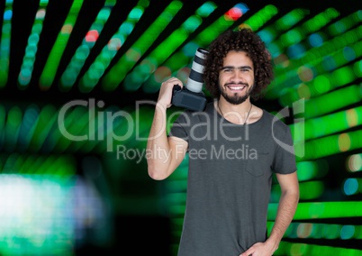 happy photographer with the camera rest on his shoulder. Green blurred lights  behind