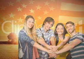 Friends with hands together agaisnt american flag and beautiful landscape
