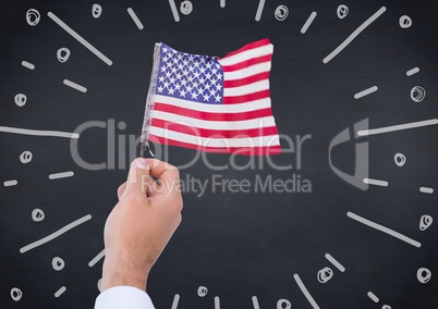 Hand holding american flag against navy chalkboard and white fireworks doodle
