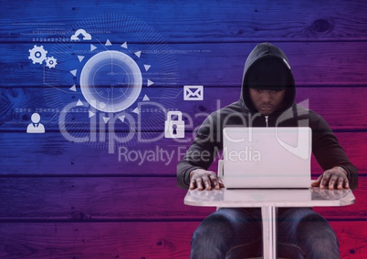 Hacker using a laptop in front of wood background with digital icons