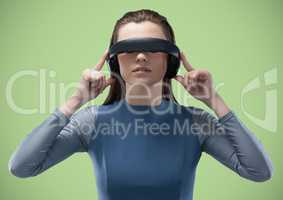 Woman in virtual reality headset against green background