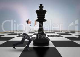 Business man pushing 3D chess piece against purple abstract background