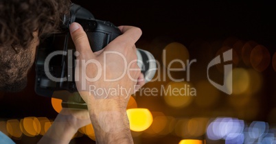 hands holding a camera against glowing background