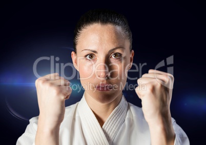 Woman in karate suit against blue flare