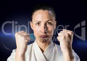 Woman in karate suit against blue flare