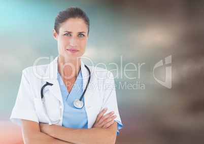 Female doctor arms folded against blurry blue brown background