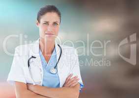 Female doctor arms folded against blurry blue brown background
