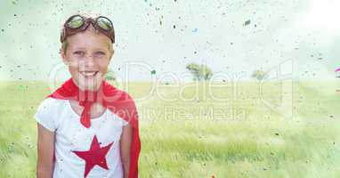 Superhero boy against meadow with flare and confetti