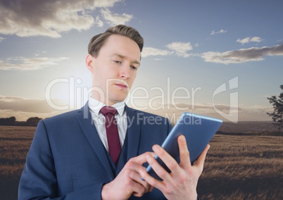 Man using a digital tablet in the countryside