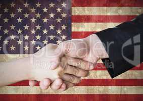 People shaking their hands together against american flag