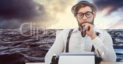 Male hipster holding tobacco pipe while looking at typewriter against 3d sea