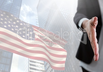 Part of a woman offering her hand against fluttering american flag and buildings