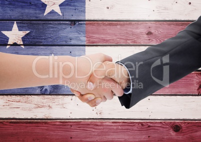 Business people shanking their hands against american flag