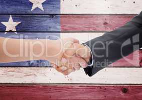 Business people shanking their hands against american flag